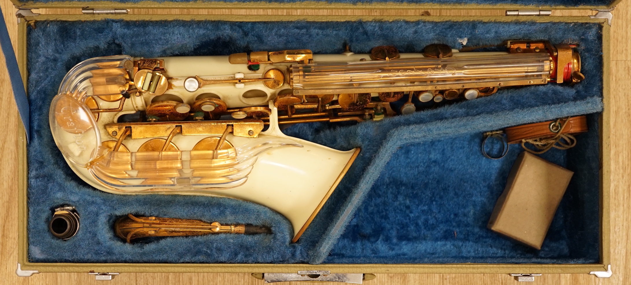A cased Grafton alto saxophone with cream plastic body and brass plated key work, serial number 13597